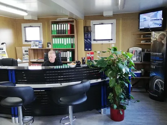 Empfangstheke mit Reifenwerbung und einer Person hinter dem Tresen
